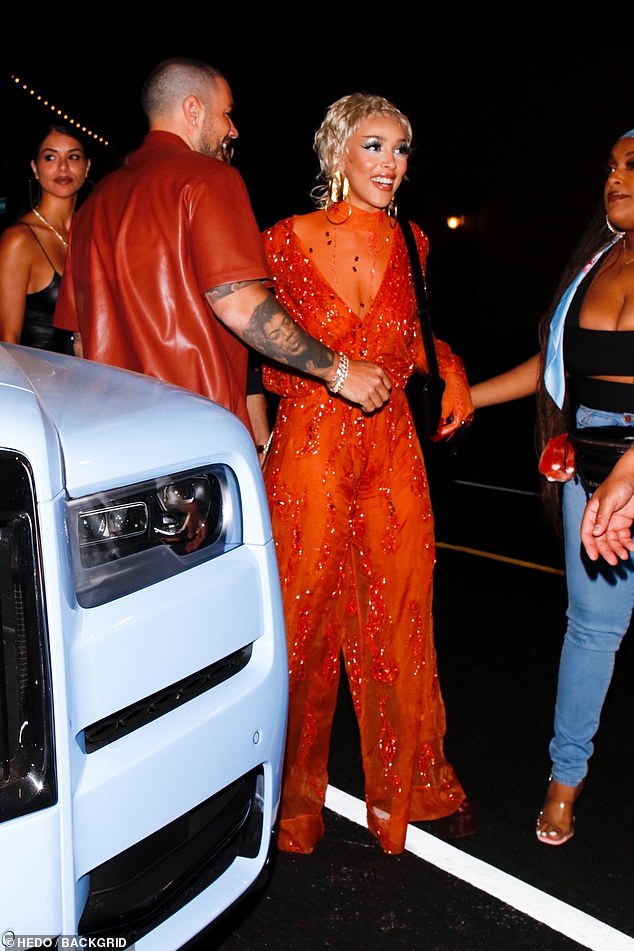All eyes on her: The singer, 25, turned heads in a plunging sheer orange jumpsuit which was adorned with beads