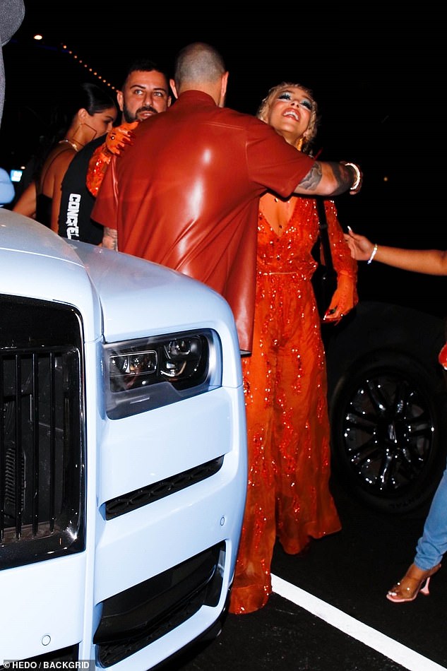 Hugs: The songstress appeared in high spirits as she greeted pals before heading to the bash