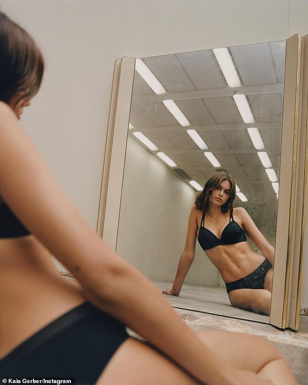 Looking in the mirror: Kaia sat on her hip as she appeared to be in an empty studio